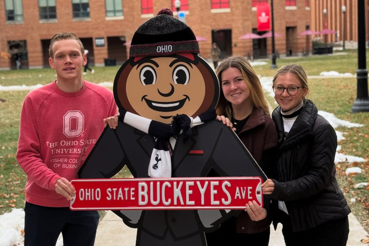Jack Drake with friends and Burtus in front of Fisher College of Business