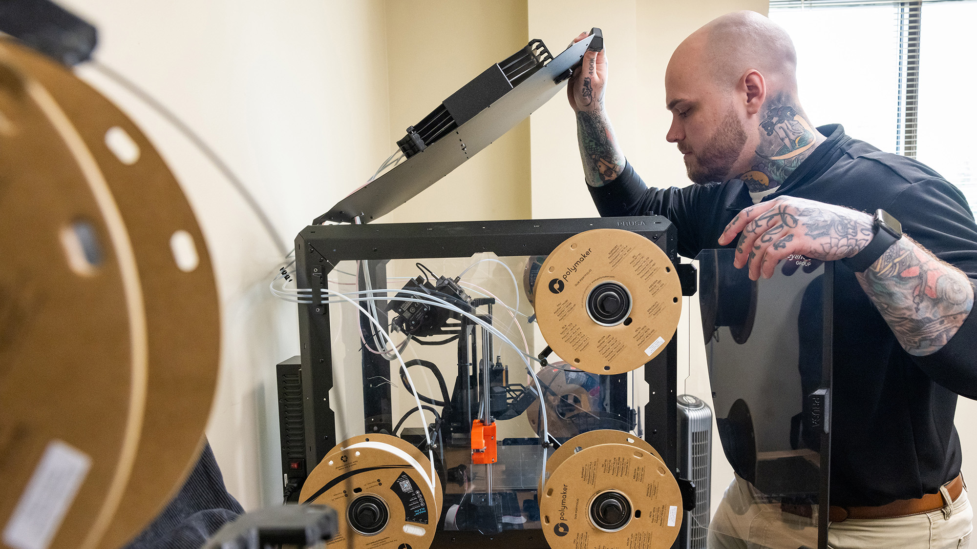 Zack Ernest designs solutions for factory machinery on his office computer, then prints prototypes on 3D printers to test the product. 