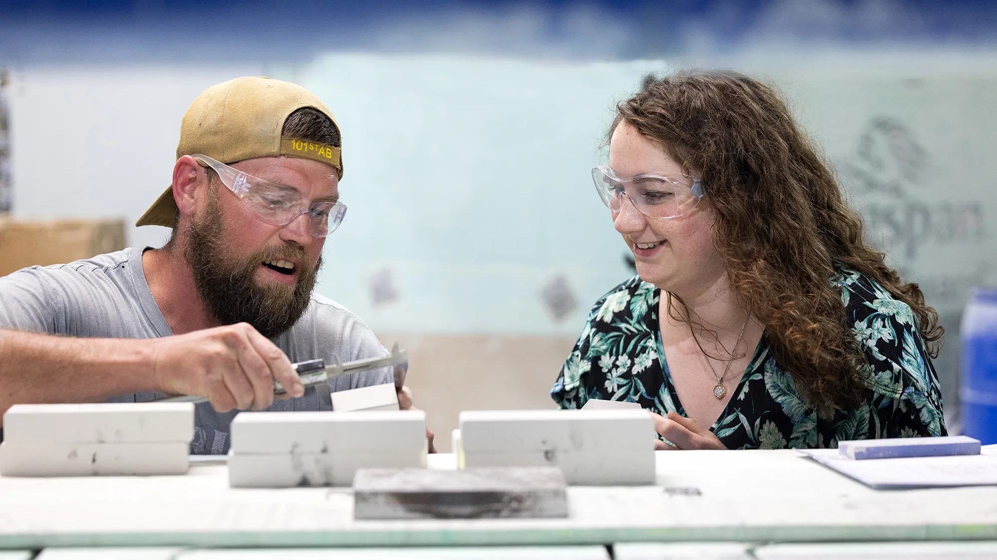 Amanda Becker works with Ted Hill, a CerCo Corp. water jet operator, to refine a cut on a ceramic brick