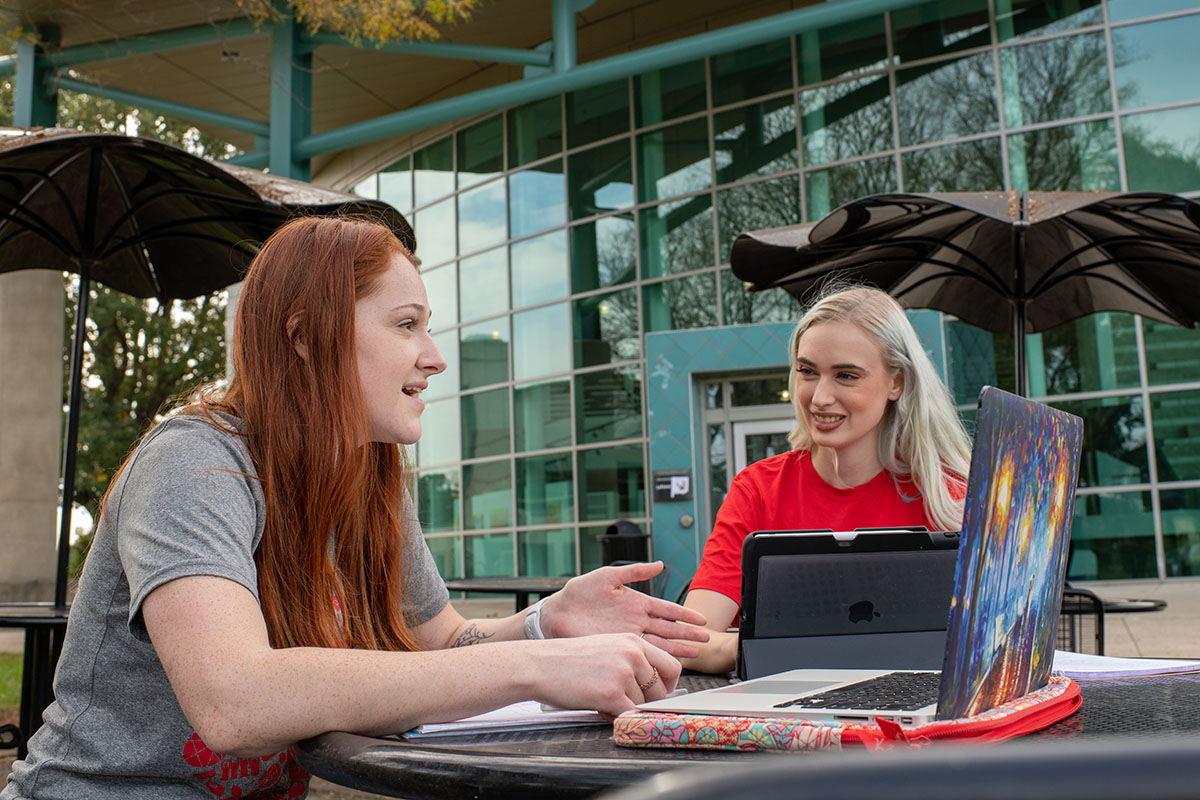 Students with laptops talking outside on the campus of The Ohio State University at Newark